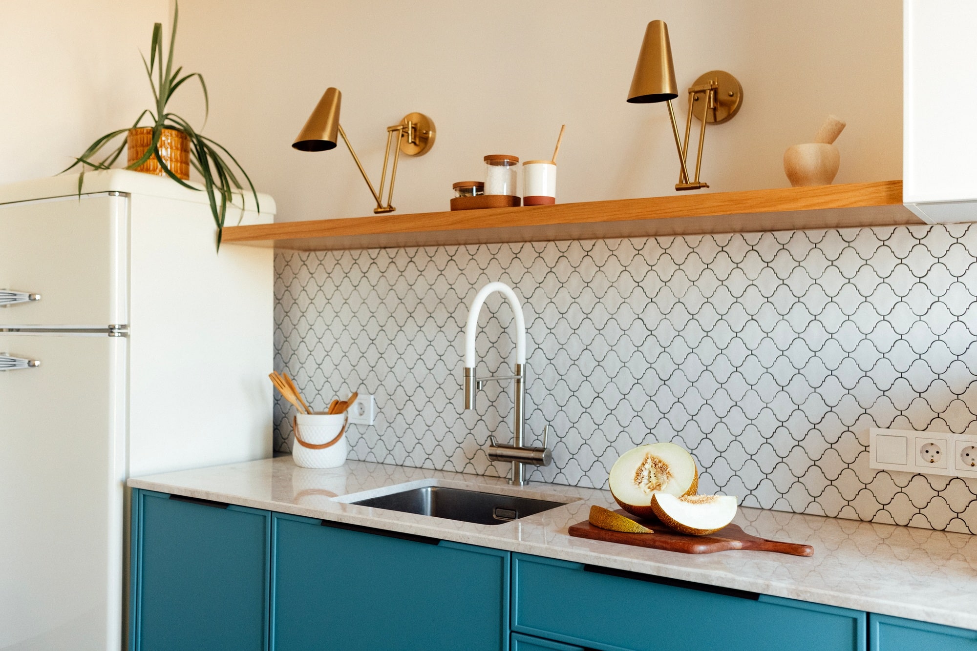 A modern kitchen with a blue set and a marble countertop