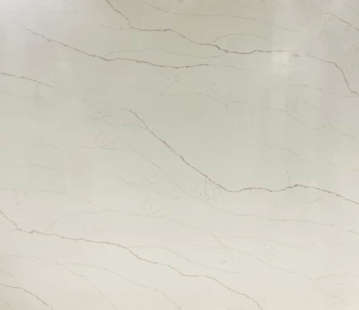 White marble slab with pale gray veining and a small Vision Quartz Exclusive logo in the top-left corner.